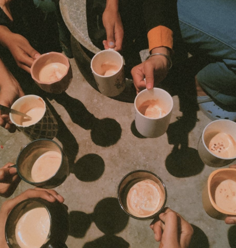 Overhead view of hands holding coffee mugs in a circle